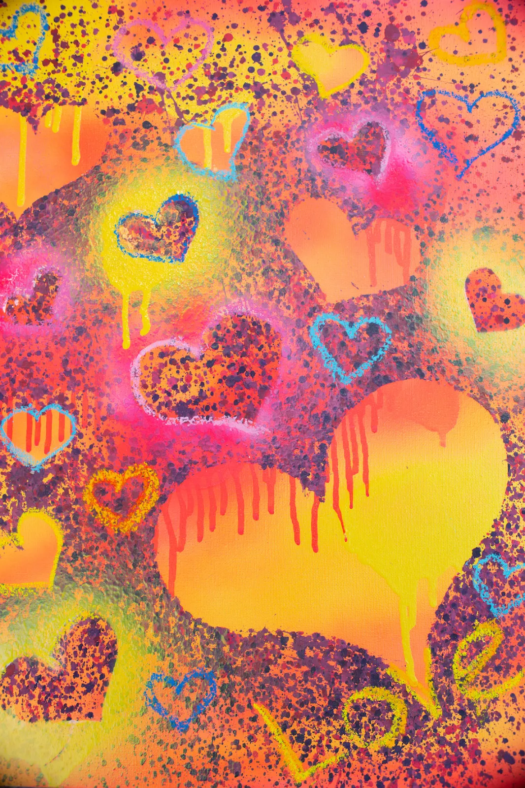 A painting of hearts in yellow, orange, pink and blue, sprayed, spattered and dripping, with “Love” written in the corner