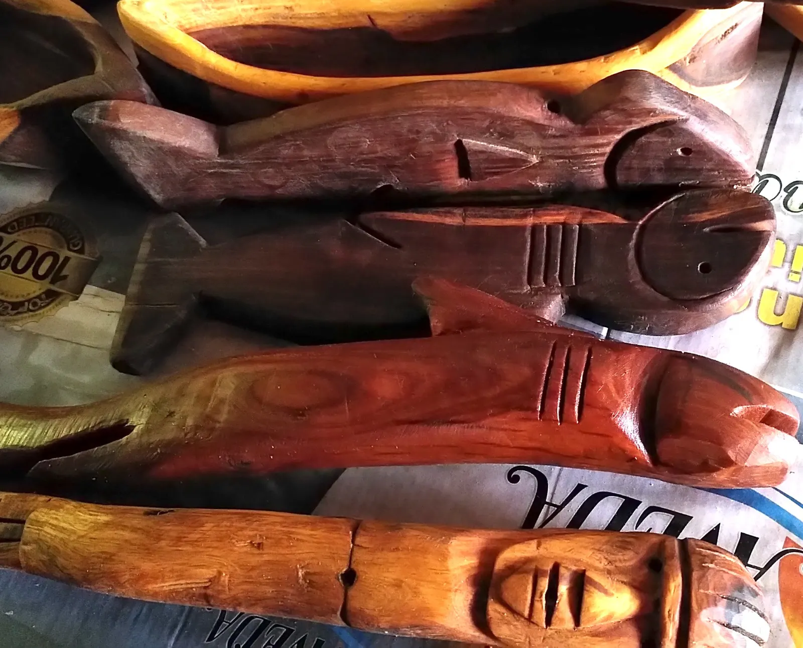 Carved and polished wooden fish, with a mermaid’s face carved at the bottom