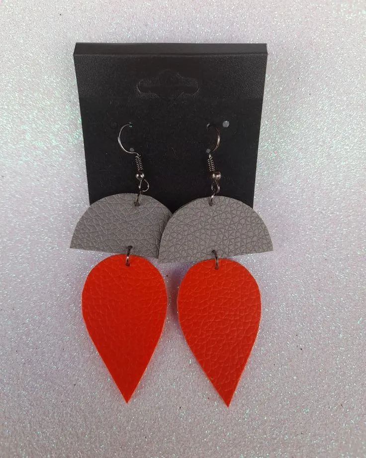 Faux leather earrings, a grey half-moon above an orange leaf, on a black card