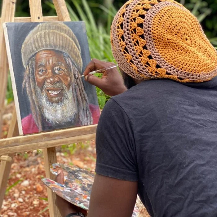 Ras Rahle Smith at his easel, painting a portrait