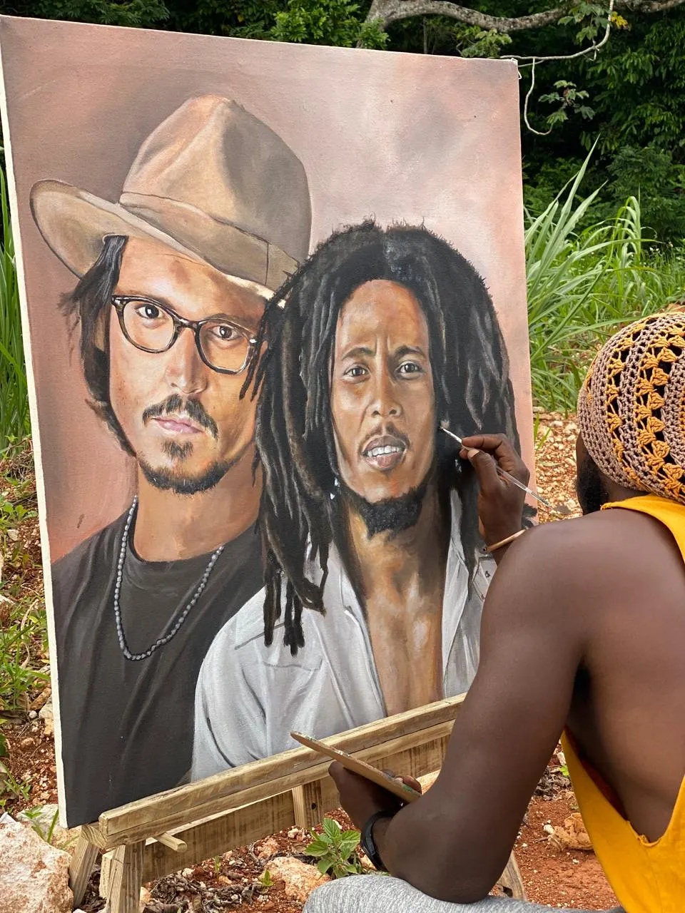 Painting a large double portrait on an easel outdoors, brush in hand