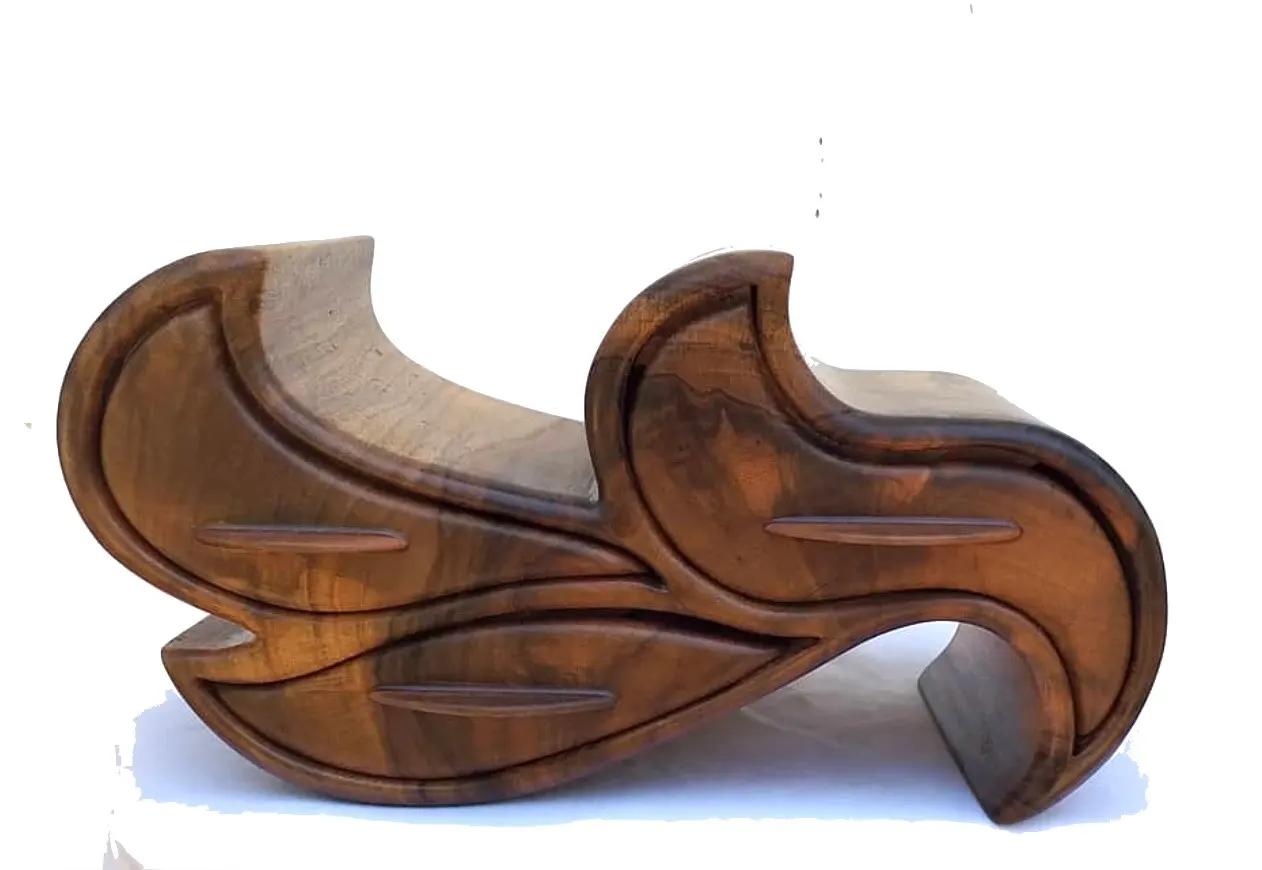 A wooden jewellery box in flowing wave shapes with three drawers