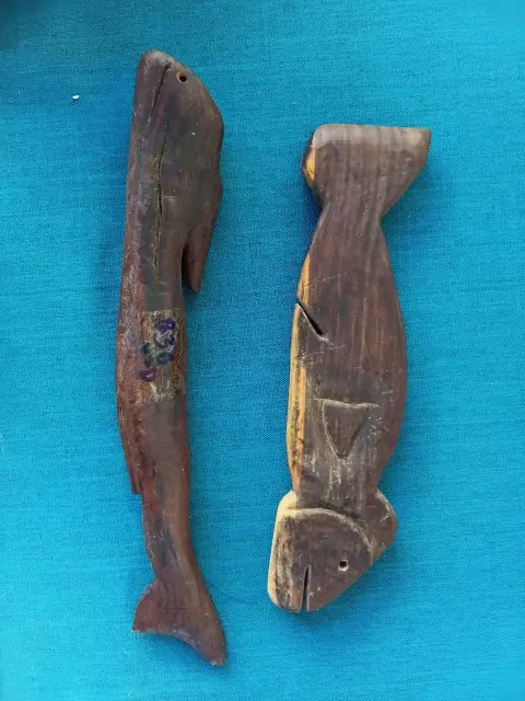 Two carved wooden fish on a blue cloth