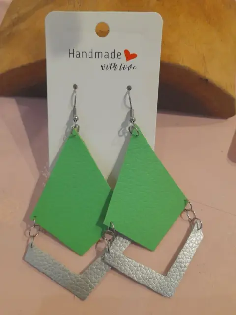 Green and silver faux leather earrings, a diamond above an open chevron, on a “Handmade with love” card