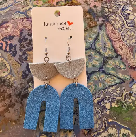 Grey and blue faux leather earrings on a “Handmade with love” card