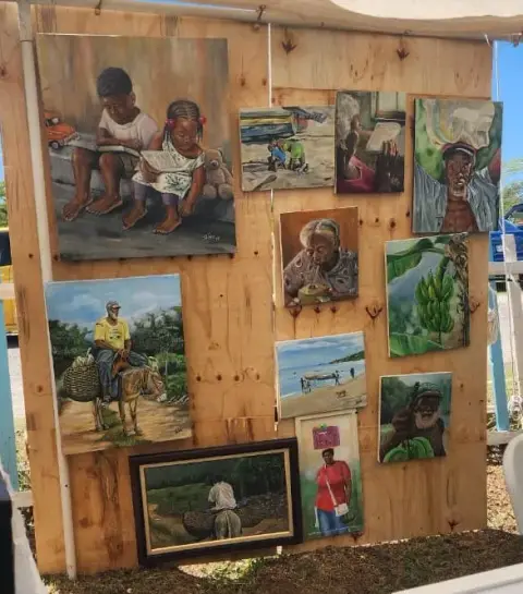 His paintings on a wooden board: children reading, a man on a donkey, portraits of elders and bananas