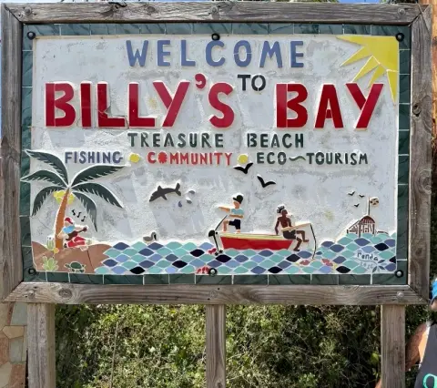 The mosaic “Welcome to Billy’s Bay” sign, with fishermen in a boat and a palm tree, signed Ronda