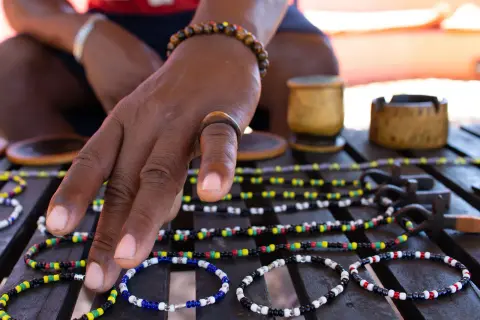 Beaded bracelets and necklaces with carved wooden pots and a wooden ring