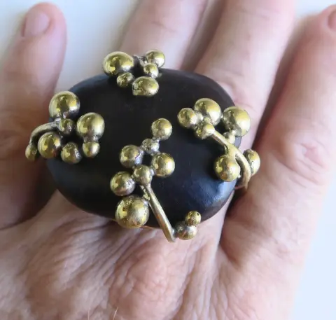 “Planets Alignment”: a ring with a dark seed set with clusters of brass beads