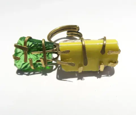A brass ring set with a green and a yellow stone
