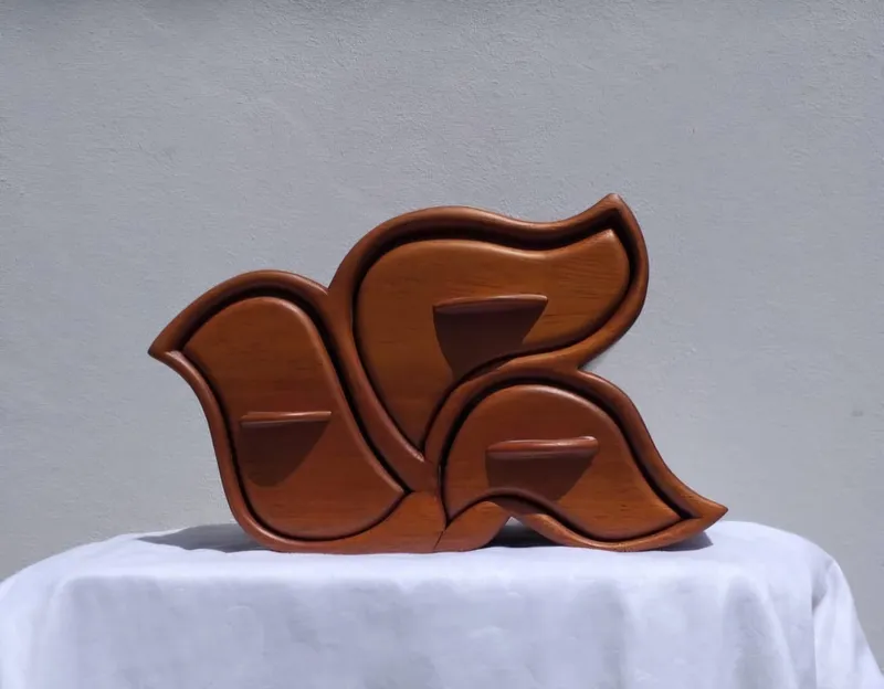 A wooden jewellery box in the shape of a bird, with three drawers
