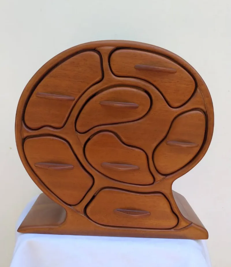 A round wooden jewellery box with eight drawers set in a spiral