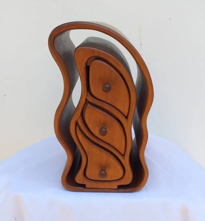 A tall jewellery box with three leaf-shaped drawers inside a wavy outer frame
