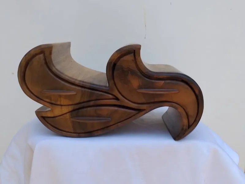 A dark wooden jewellery box in leaf shapes, with three drawers