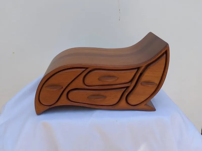 A wooden jewellery box in flowing wave shapes, with four leaf-shaped drawers