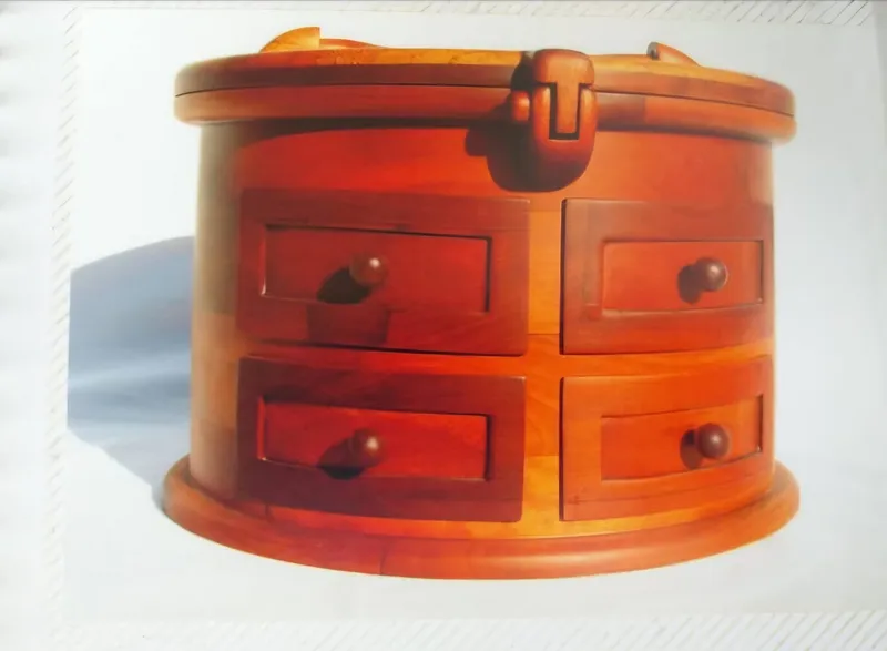 A round wooden chest with a latched lid and four drawers