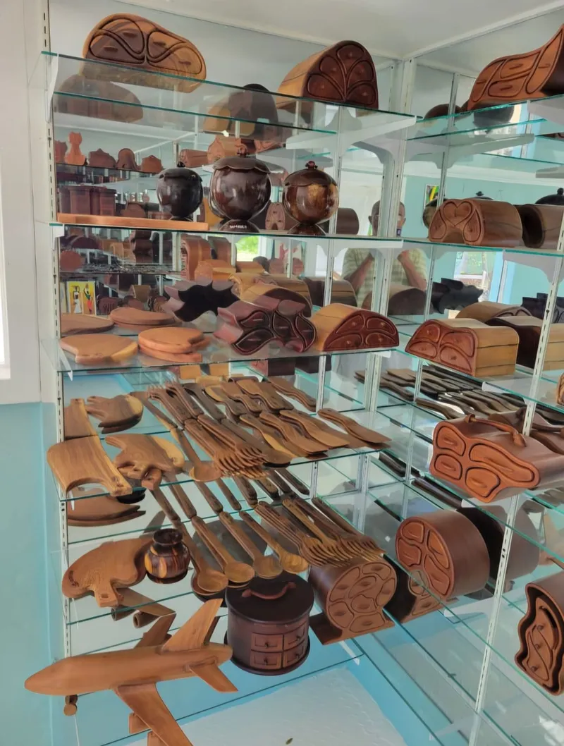 Glass shelves in the shop with jewellery boxes, spoons, forks, chopping boards and a carved aeroplane